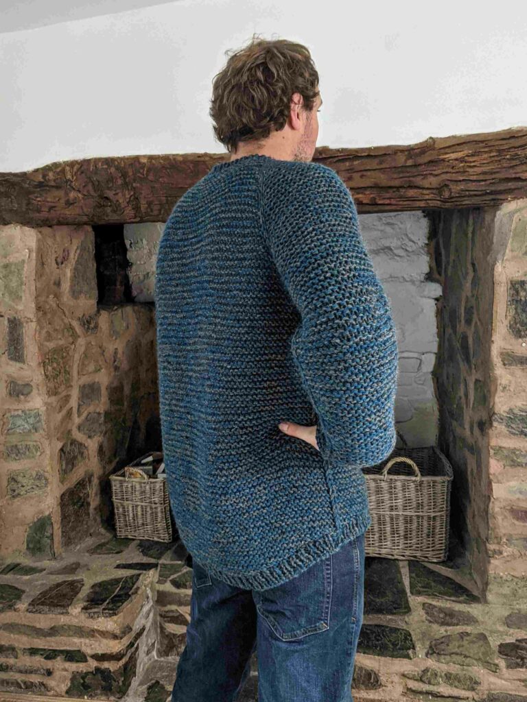 back/side view of the garter squish adult jumper showing the dropped hem at the back and the slip stitch detailing down the side of the body.