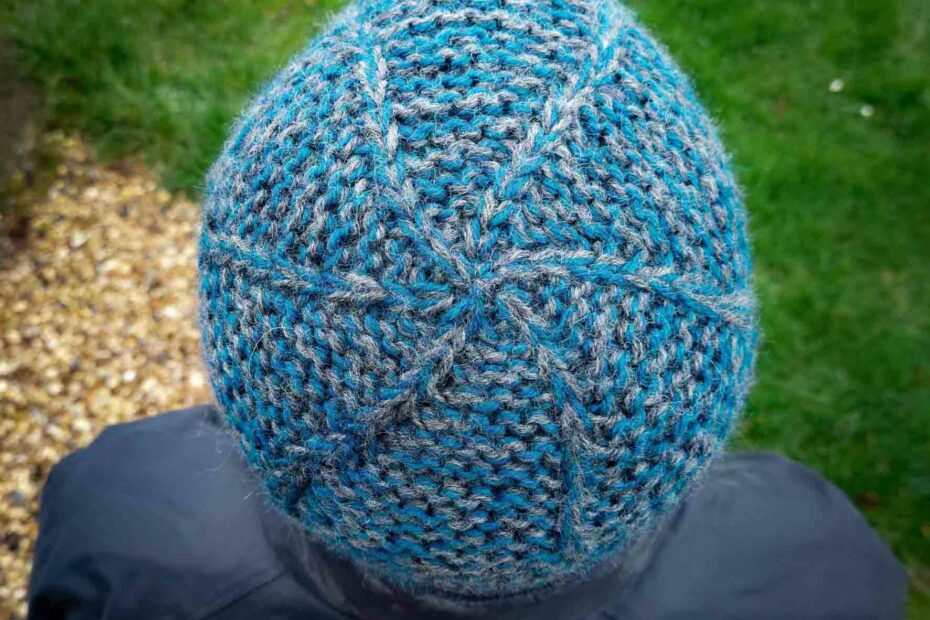 view of the garter squish beanie from the top, showing the crown which has slip stitches swirling out from the centre and the main hat is knit in garter stitch