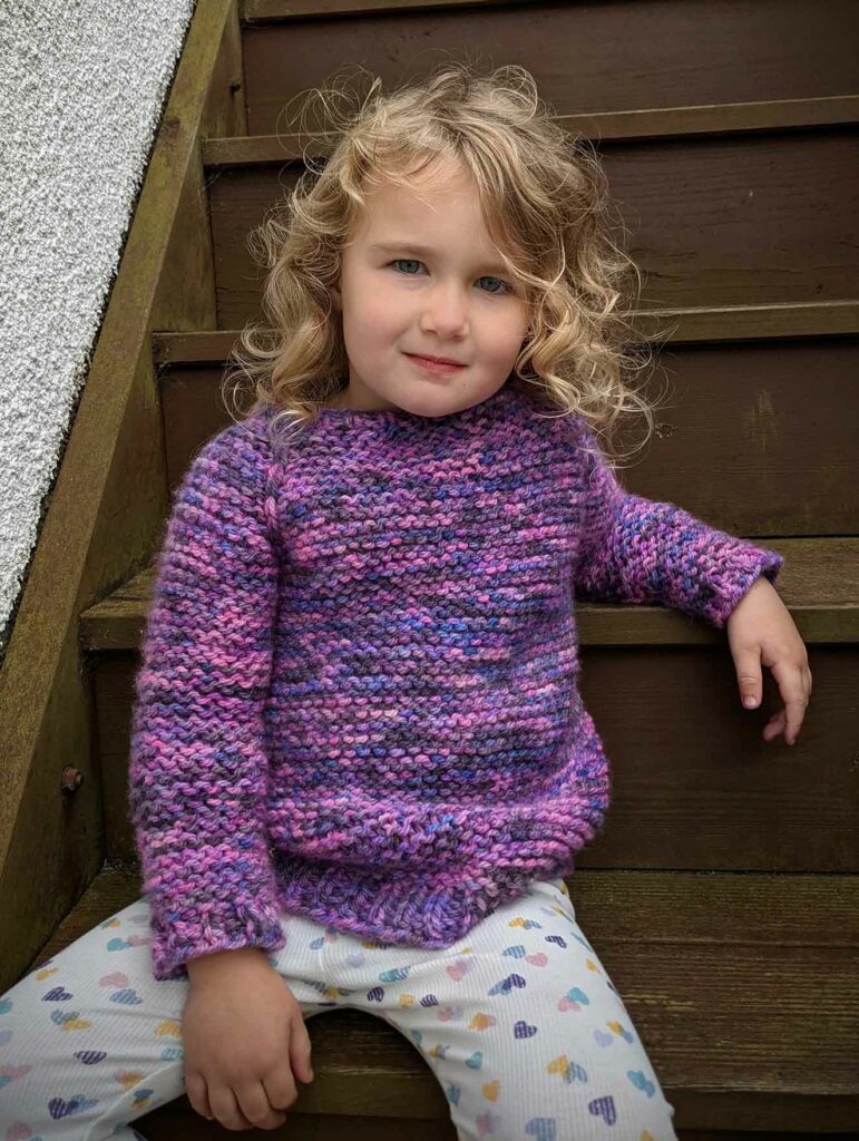 garter squish kids jumper from the front. All over garter stitch and shaped neckline visible with slipped knit stitches along the raglan shaping