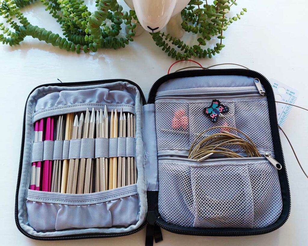 photo of an open knitting needle case - one side is full of Addi Click needles, the other size shows mainly the accompanying cables inside a zipped pocket